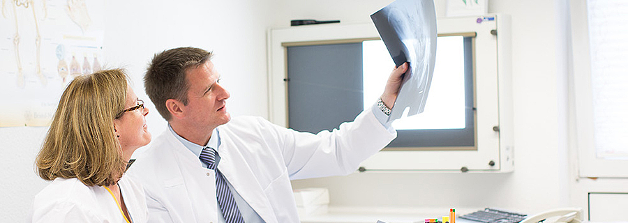 Der Chefarzt der Rehaklinik Höhenblick und eine Pflegefachfrau betrachten gemeinsam eine Röntgenaufnahme.